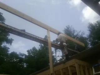 Carpenter setting a ridge beam over a new addition frame — Ice Dam Removal by Roofing Brothers in Pelion