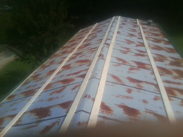 Rusted metal roof panels with new wood purlins before replacement — Storm Damage Roof Repair in Pelion by Roofing Brothers