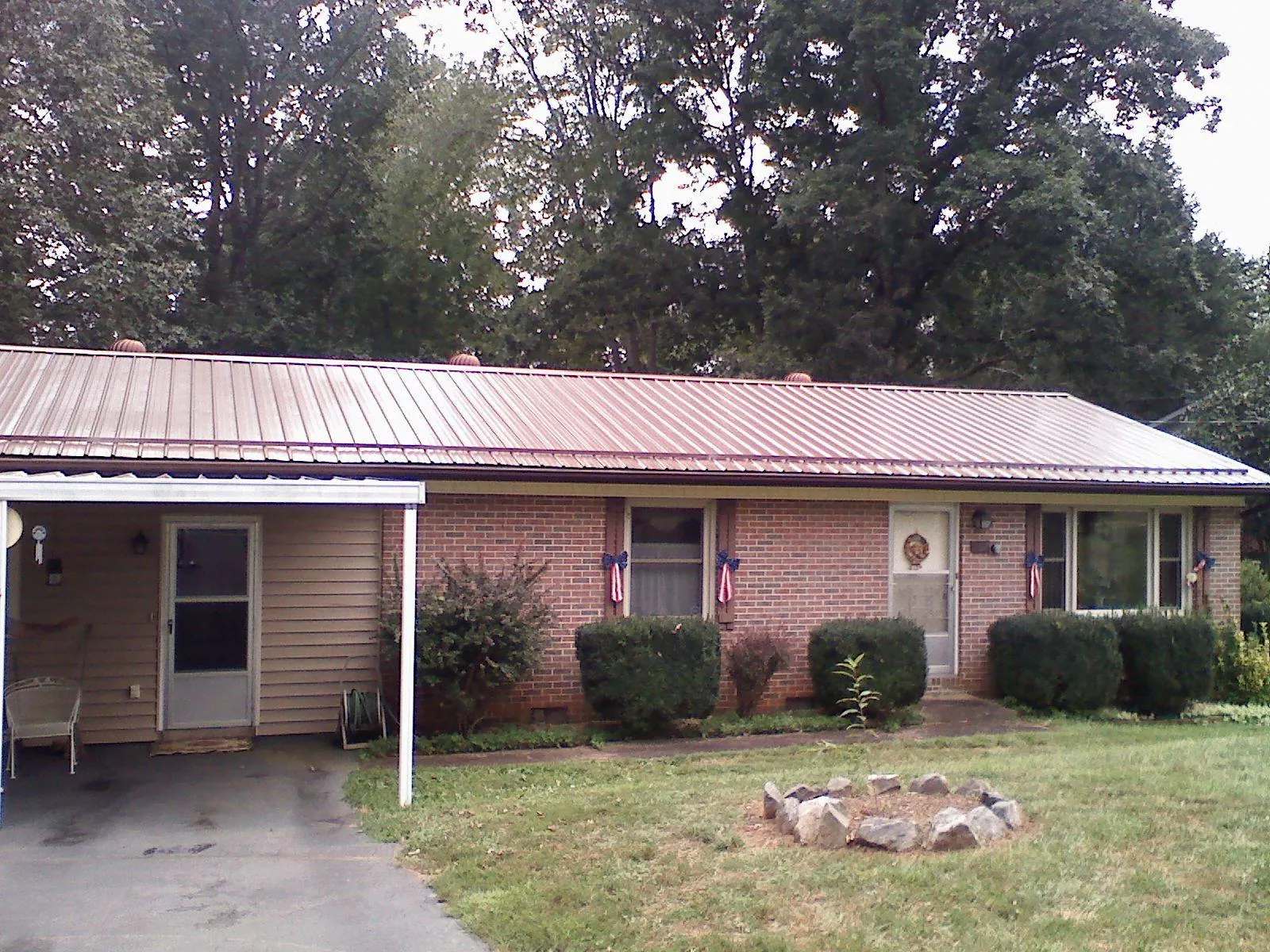 Bronze metal roof and carport on a brick ranch home — Roof Repair work by our crew in Pelion